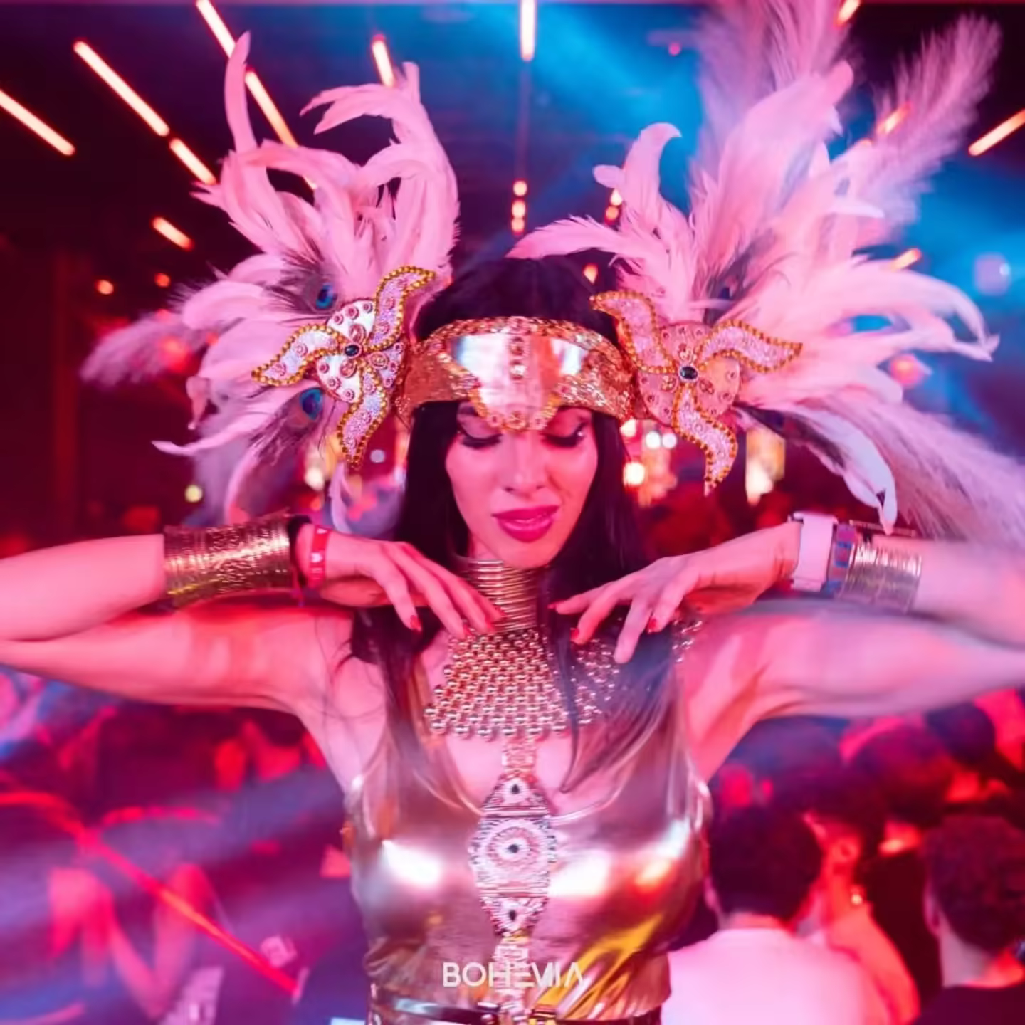 Performer Queen’s Angels con un grande copricapo di piume e costume luminoso